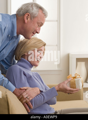 Überraschende Frau mit Geschenk Stockfoto