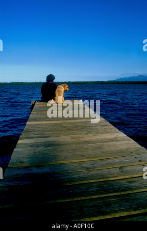 Frau und ihr Welpe sitzt auf dock Stockfoto