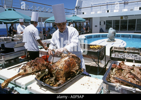 Köche Braten ganze Lämmer zum Grillen an Deck im Südpazifik an Bord der MV Discovery Cruise Stockfoto