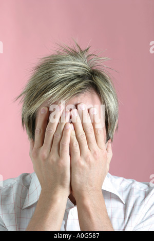 Ist junger Mann mit seinem Gesicht in die Hände Stockfoto