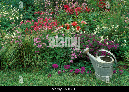 Ihre alte Gießkanne: Antike Gießkanne und alte altmodische Blumengarten der Pastell-Farben, in Missouri Stockfoto