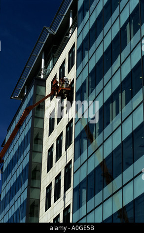 Männer, die auf mobilen high-Lift außerhalb neue Büro komplexe Manchester Stockfoto