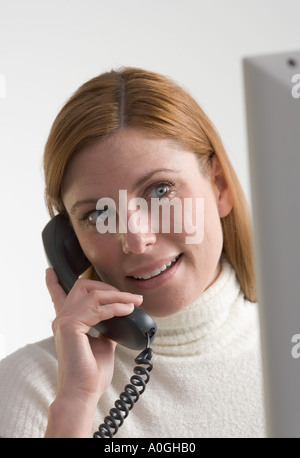 Frau am Telefon mit computer Stockfoto