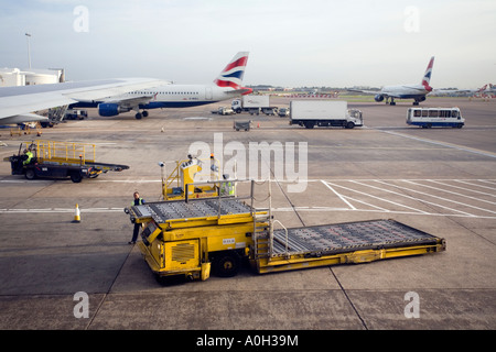 DIE GEPÄCK-LKW LEER NACH DEM LADEN DES FLUGZEUGS AM FLUGHAFEN HEATHROW Stockfoto