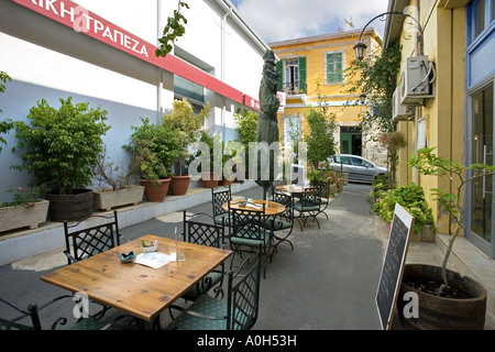 EINE TYPISCHE SCHMALE STRAßE MIT TISCHEN UND STÜHLEN VOR EINEM RESTAURANT IN PAPHOS ZYPERN Stockfoto