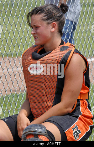 Weibliche Teenager Hauptliga Softball Spieler sitzen auf der Bank tragen die Catcher Schutz Weste und Knie-pads Stockfoto