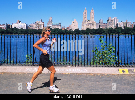 Frau joggt auf dem Jacqueline Kennedy Onassis Reservoir oder dem Central Park Reservoir, Upper East Side Manhattan, Central Park West im Hintergrund. Stockfoto