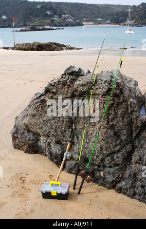 Angeln oder Fischen Box und Stäbe gelehnt Felsen am Strand Stockfoto