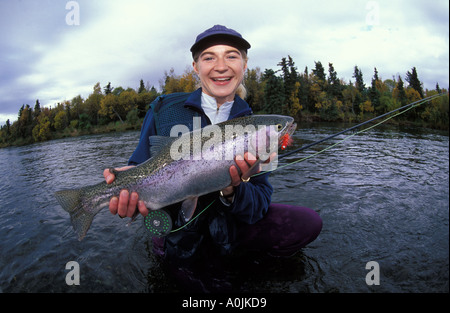 Südosten ALASKAS Katmai National Park Brooks Lodge lächelnde Frau Fliegenfischer Freigabe Regenbogenforellen in den Brooks River Stockfoto