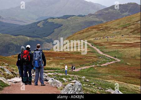 Drei Personen beobachten Wanderer auf dem Weg zum Ben Nevis in Schottland Stockfoto