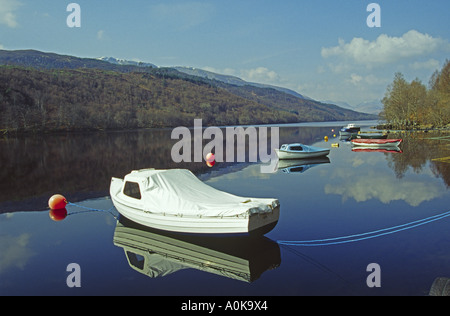 Ein ruhiger Frühlingstag auf Loch Arkaig in den westlichen Highlands von Schottland mit den festgemachten Boote im Wasser reflektiert Stockfoto