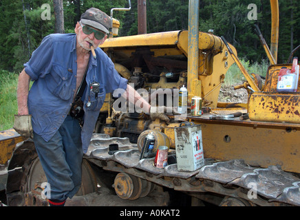 Porträt des alten Bauern arbeiten auf einem Traktor in Hinterwäldler Montana Stockfoto