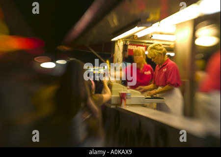 Ein Hot Dog Verkäufer übergibt einer Mädchen ein Corndog auf der Western Idaho Fair in Boise, Idaho. Stockfoto