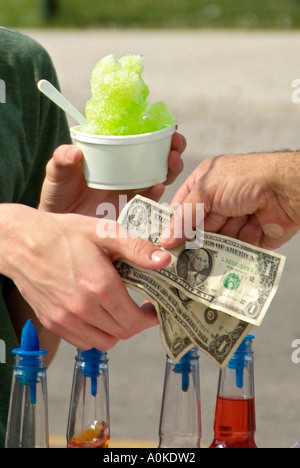 Geld tauscht Hände nach Kauf für ein Eis auf einem Jahrmarkt Stockfoto