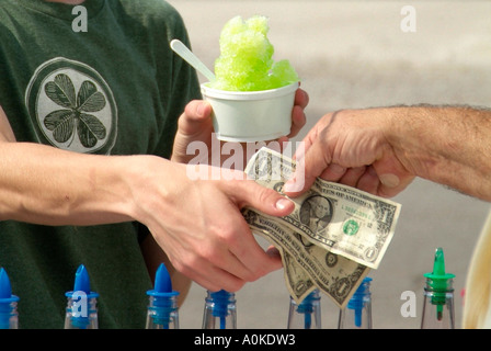 Geld tauscht Hände nach Kauf für ein Eis auf einem Jahrmarkt Stockfoto