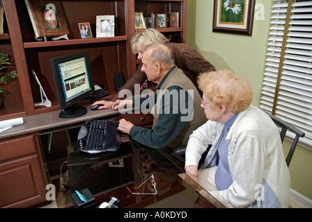 Erwachsene Tochter lehrt Senioren Eltern wie Surfen im Internet auf einen Computer zu Hause Stockfoto