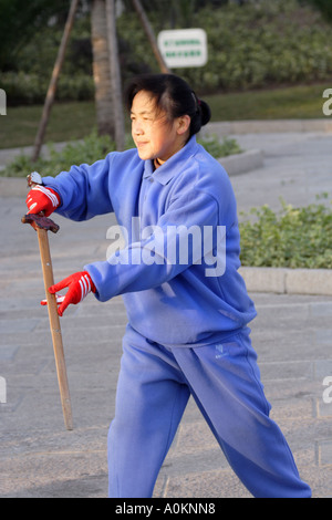 Frau Praktiken mit Schwert auf dem Bund in Huangpu Park in Shanghai, China Stockfoto
