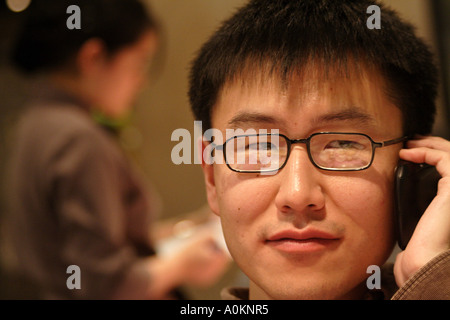 Junge koreanische Mann einzureden ein Blackberry in einem Restaurant, Shanghai, China Stockfoto