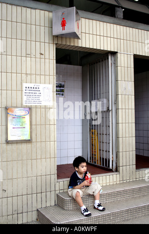 Boy wartet Mutter auf der Toilette in der alten Central Market Central, Hong Kong Stockfoto