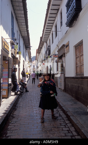Schmalen gepflasterten Straße und eine Frau mit einem Kind auf dem Rücken in Cusco in Peru Stockfoto