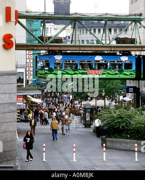 Ein Zug auf der Wuppertaler Schwebebahn Monorail führt über eine Fußgängerzone im Stadtzentrum Elberfeld, Wuppertal, Deutschland. Stockfoto