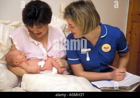 junge Gemeinde Hebamme auf Hausbesuch mit neuen Mutter Post natal Notizen Stockfoto