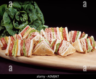 sortierten Sortiment Clubsandwich Speck Salat Tomate Tomaten Chicken Salat Thunfisch Schinken Käse Schneidbrett aus Holz Toast getoastet Stockfoto