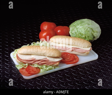 2 zwei Sub Sumarine Sandwich Bologna Türkei Käse Salat Tomate Tomaten Schneidebrett rollt Textfreiraum Stockfoto