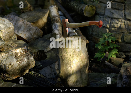 Axt im Protokoll auf Holzstapel Stockfoto