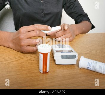 Weibliche Diabetiker prüft ihre Blutspiegel sugar.glucose. Stockfoto