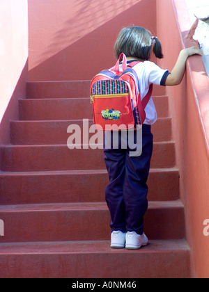 Der erste Schultag das kleine Schulmädchen 4-6jährig denkt an die Schritte, die zum Klassenzimmer führen. Unsicher, schüchtern, nervös, die ersten Tage an der neuen Schule. Stockfoto