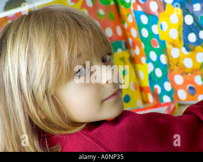 INFANT SCHOOL GIRL FARBE LESEN BILD BUCH Nahaufnahme von Kleinkind Mädchen sitzen am Schreibtisch in Kindergarten Stockfoto