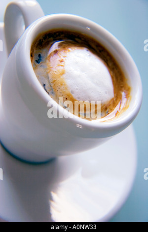Weiße Espressotasse und Untertasse mit frisch zubereiteten Kaffee auf einem Winkel fotografiert Stockfoto