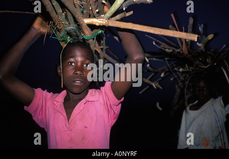 Ein Junge mit Brennholz nach Hause am Ende des Tages Stockfoto