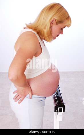 Schwangere Frau im Maßstab Stockfoto