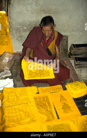 Ein tibetischer Mönch arbeiten an Heiligen Papiere und blättert in einem Kloster in Tibet. Stockfoto