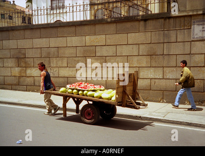 'Keep on Going 2' Mann ziehen schwere zwei Rad Holz Wagen Spaziergang tragen verkaufen Wassermelone Obst Bogotá Kolumbien Südamerika Latein Stockfoto