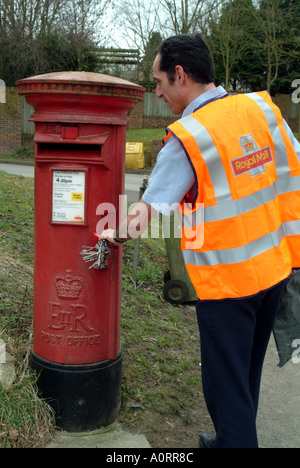 Postbote leert sich leerende Briefkasten Box in ländlicher Umgebung England UK Royal Mail sperren Briefkasten Stockfoto