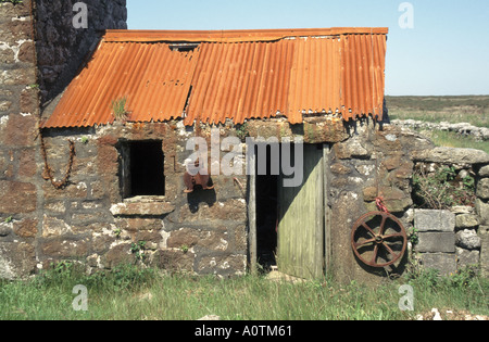 Verfallende rote Rostbleche aus Wellpappe auf dem Dach eines alten, verfallenen Steinbauernhofs, der Morvah Cornwall England UK überholte Stockfoto