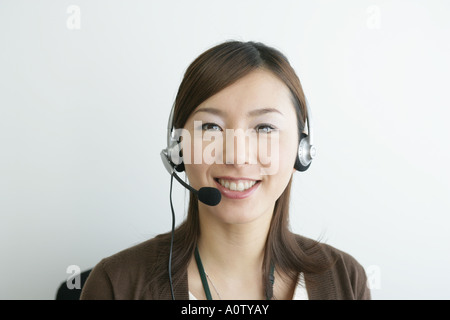 Porträt einer Geschäftsfrau einen Kopfhörer tragen und lächelnd Stockfoto