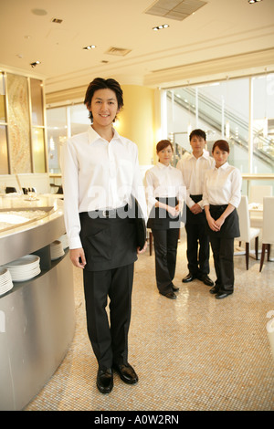 Porträt von zwei Kellner und zwei Kellnerinnen stehen in einem restaurant Stockfoto