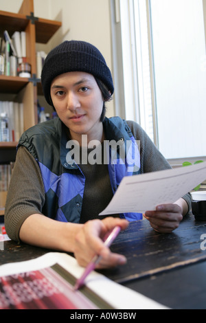 Porträt eines Geschäftsmannes, halten ein Blatt Papier und einen Stift in einem Büro Stockfoto