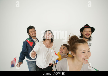 Nahaufnahme einer jungen Frau hält eine japanische Fahne mit vier jungen Männern suchen fröhlich Stockfoto