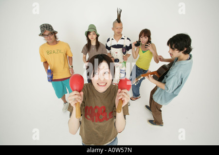 Erhöhte Ansicht von drei jungen Paaren, die Musikinstrumente spielen Stockfoto