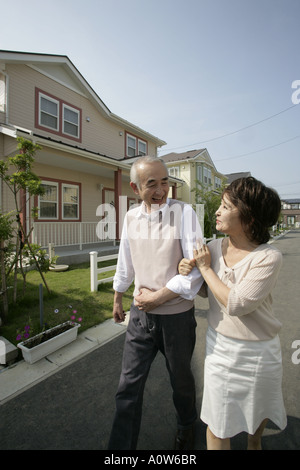 Älteres Paar gehen Arm in Arm auf der Straße Stockfoto