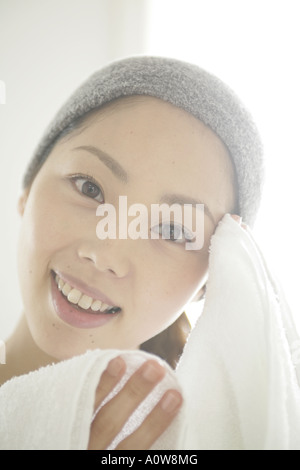 Porträt einer jungen Frau, die Stirn mit einem Tuch abwischen Stockfoto