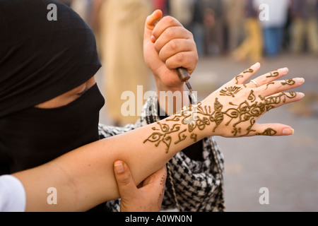 Frau Anwendung eine Henna-Tattoo auf eine Touristen-Hand im Markt Djemaa el-Fna in Marrakesch Marokko Stockfoto