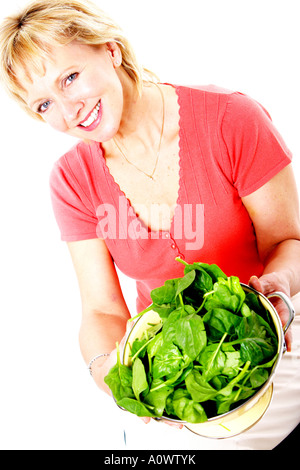 Reife Frau mit Sieb Spinat Blätter Modell veröffentlicht Stockfoto