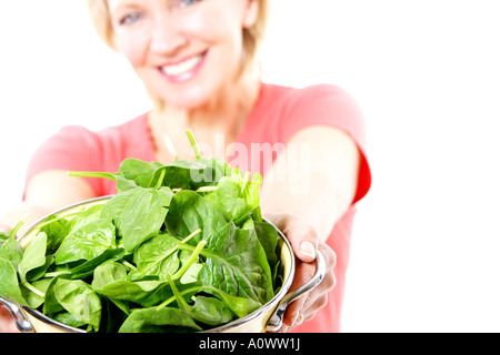 Reife Frau mit Sieb Spinat Blätter Modell veröffentlicht Stockfoto