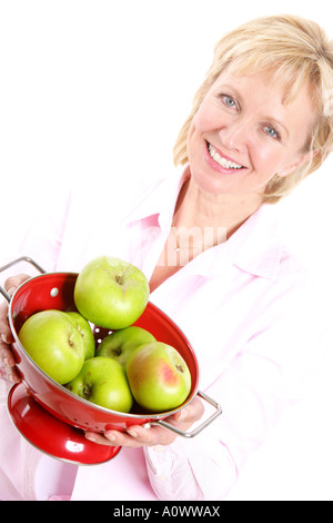 Reife Frau mit roten Sieb der Frische, grüne Äpfel kochen Isoliert gegen einen weißen Hintergrund mit einen Freistellungspfad Stockfoto